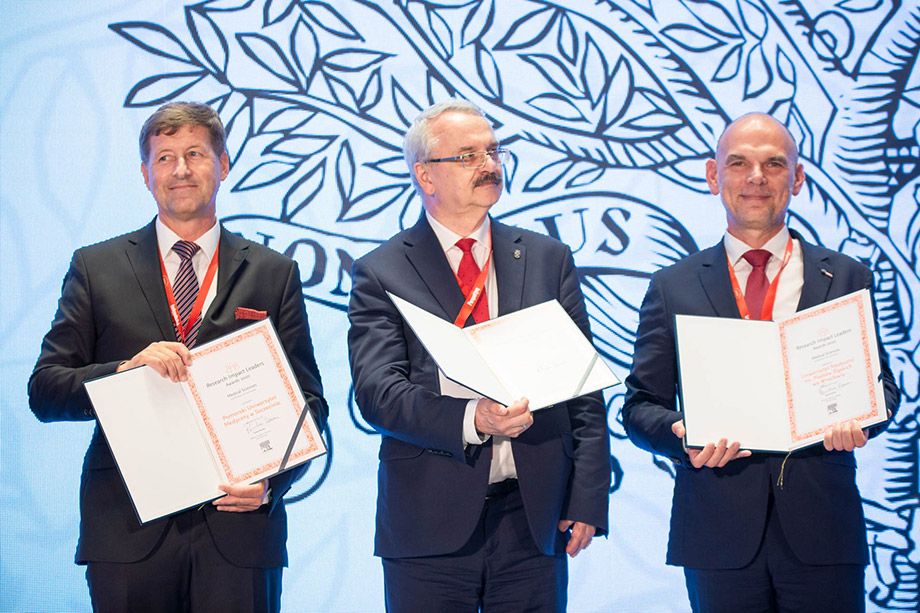 Three representatives of awarded universities, including Prof. Jarosław Górniak, present their award diplomas.