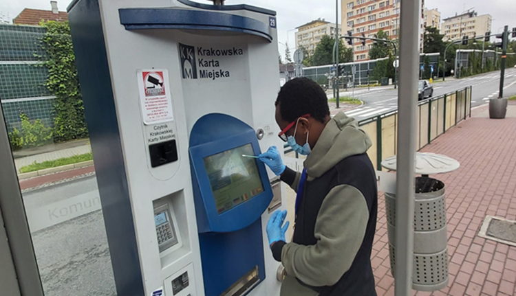 Man collecting microbe sample from a ticket machine.
